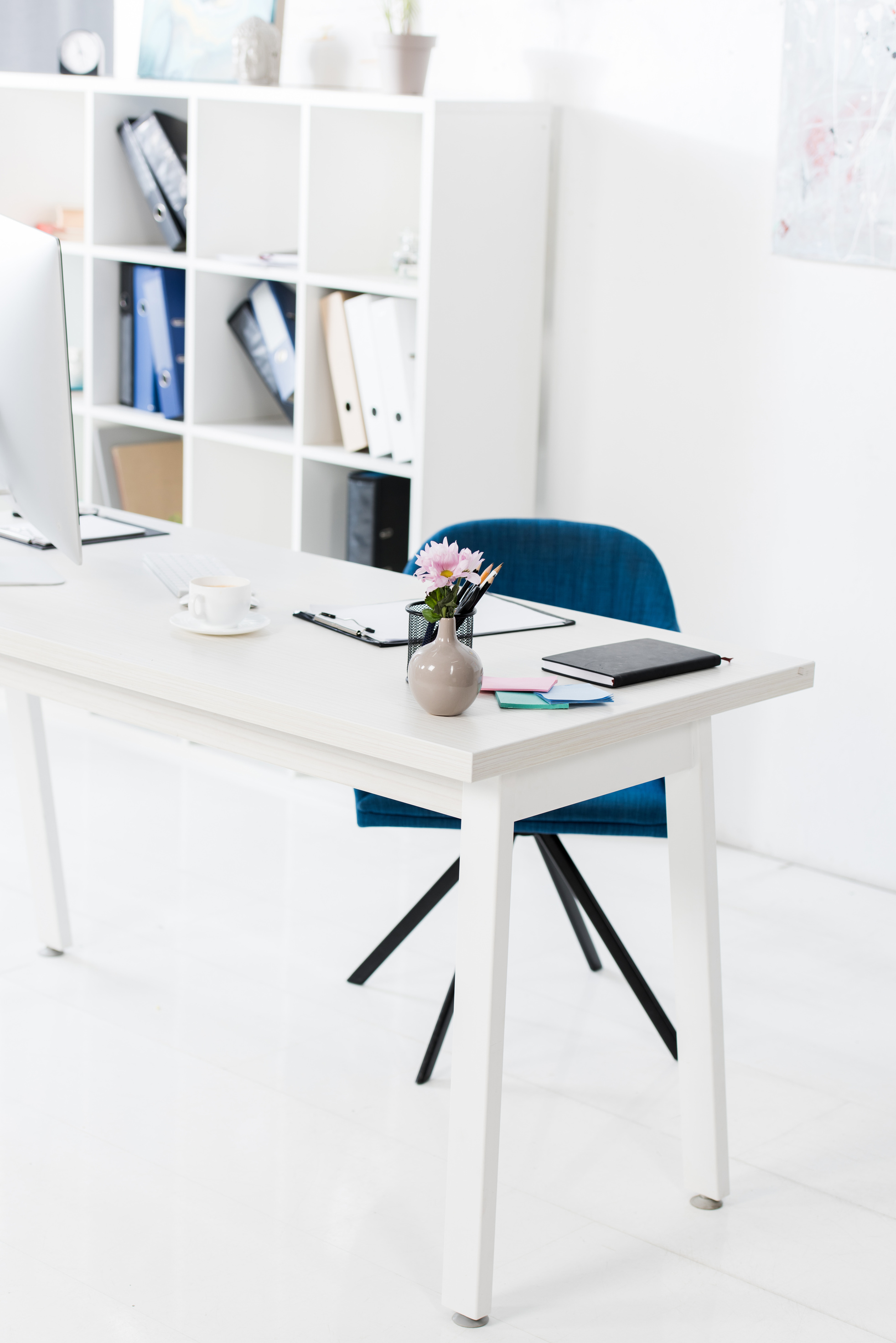 cup of coffee, vase and clipboard on table in business office